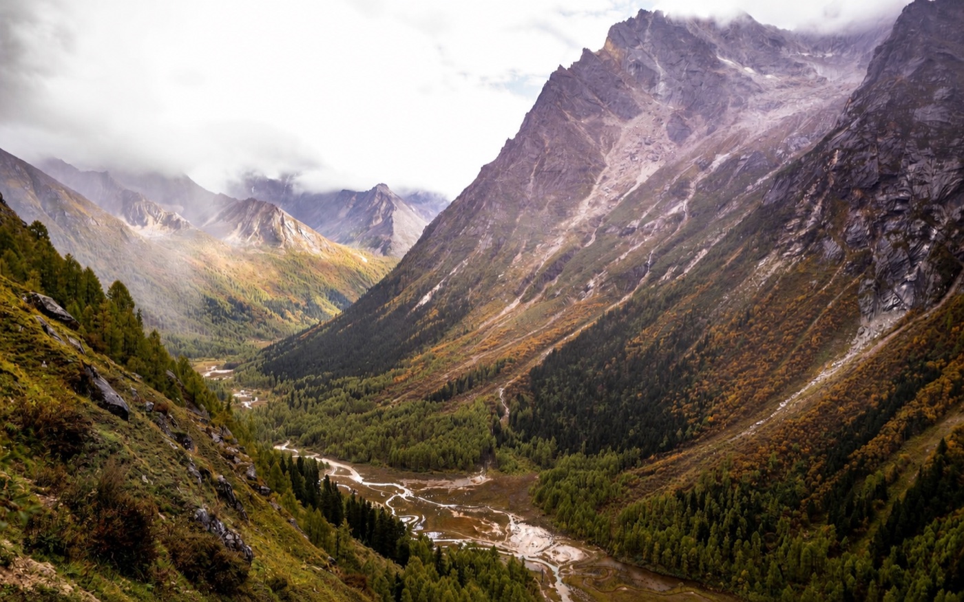 Misty mountain valley and winding river at Mount Siguniang in western Sichuan